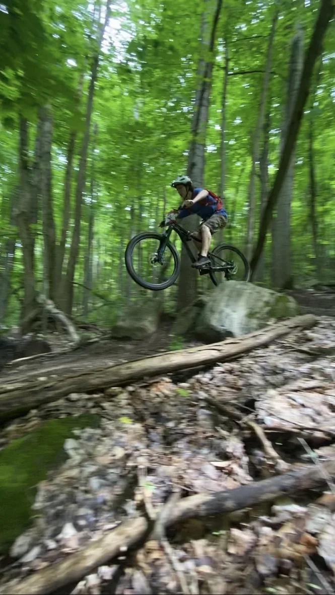 Elias mountain biking on a forest trail.