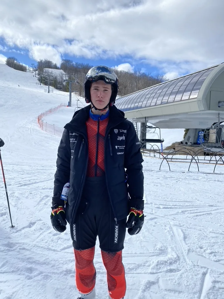 Elias outdoors in ski gear on a snowy mountain.