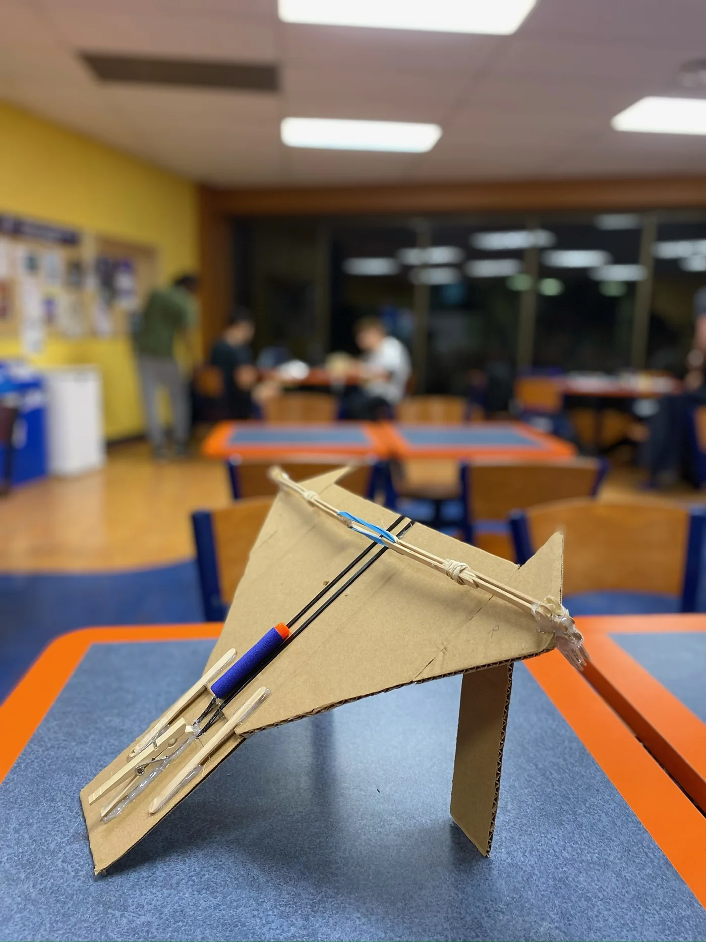 The crossbow-inspired launcher made from wooden sticks, cardboard and elastic bands.